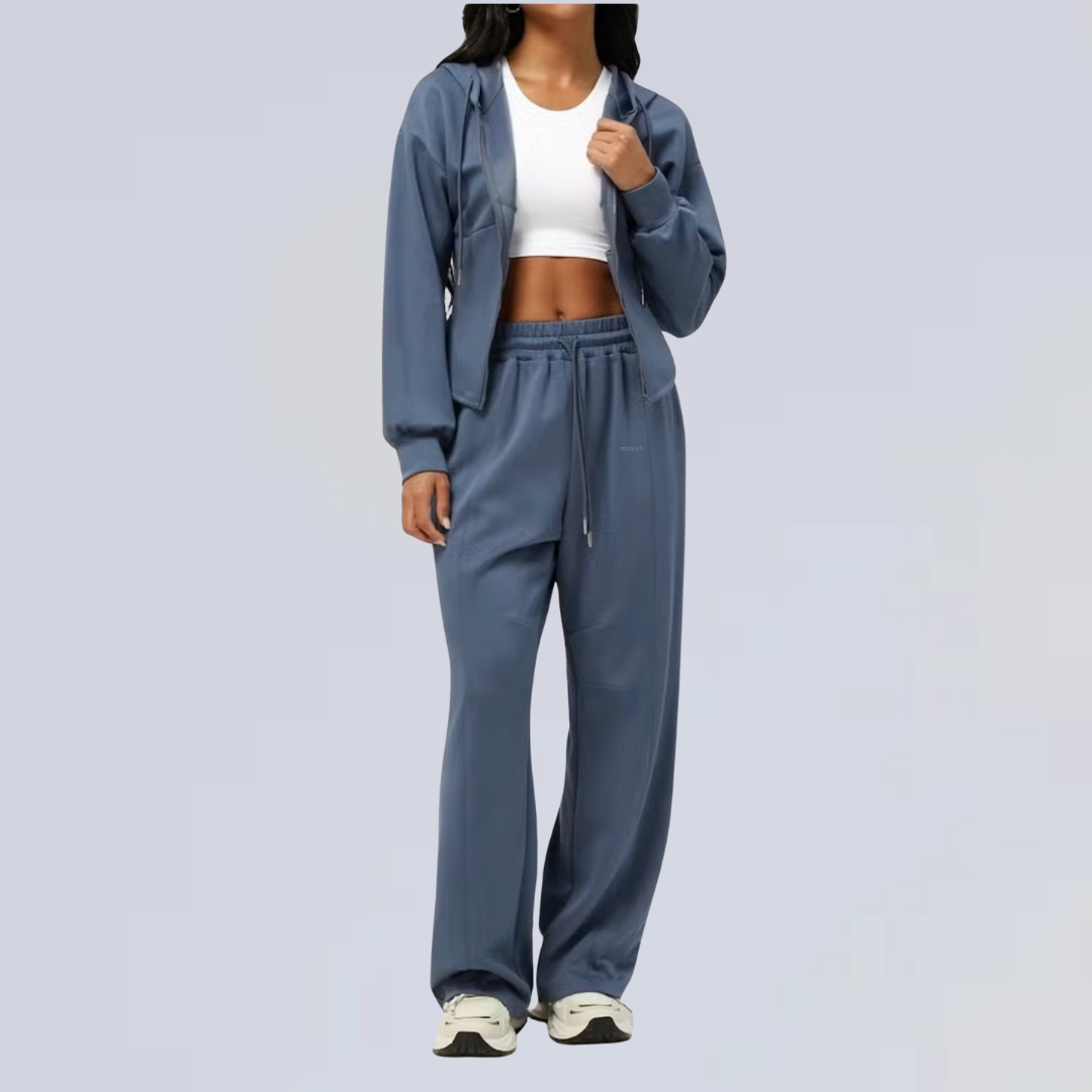 Person wearing a dark blue tracksuit on a light gray background